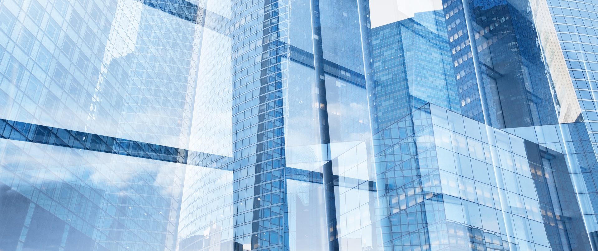 Sunlit glass office towers viewed from below
